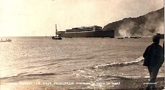 The hull goes down into the sea at Riva Trigoso in 1908, still without funnels. A postcard with the printed caption «La nave Principessa Mafalda scende in mare» (The ship Principessa Mafalda goes down into the sea).