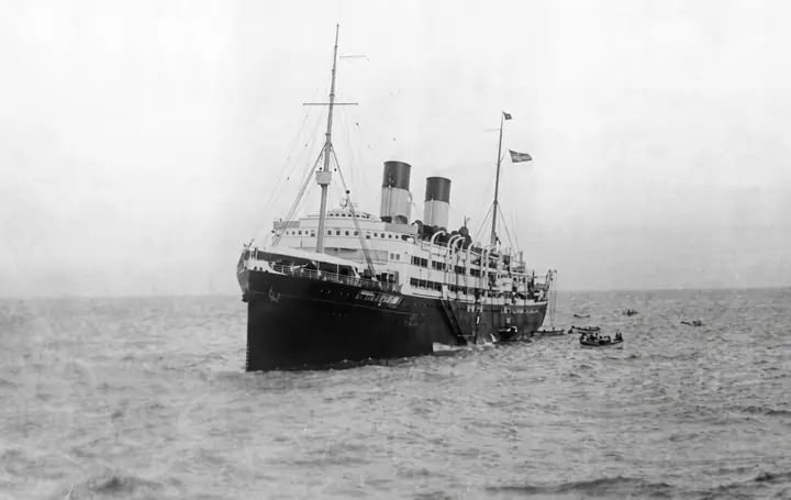 The ship in profile, with a boat on the starboard side.