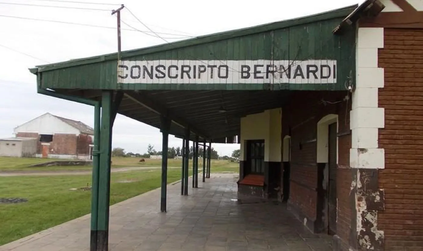 La stazione ferroviaria Conscripto Bernardi, con il cartello del nome sotto la tettoia verde del binario.